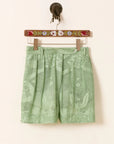 Deena Eucalyptus shorts with floral pattern on a hanger against a white background