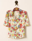 Floral patterned shirt on a hanger against a white background