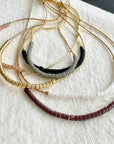Set of beaded necklaces on a textured white surface