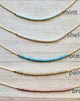 Ocean Break up Set of five necklaces with different color options on a wooden surface