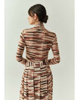 Woman wearing a patterned dress with a plain background