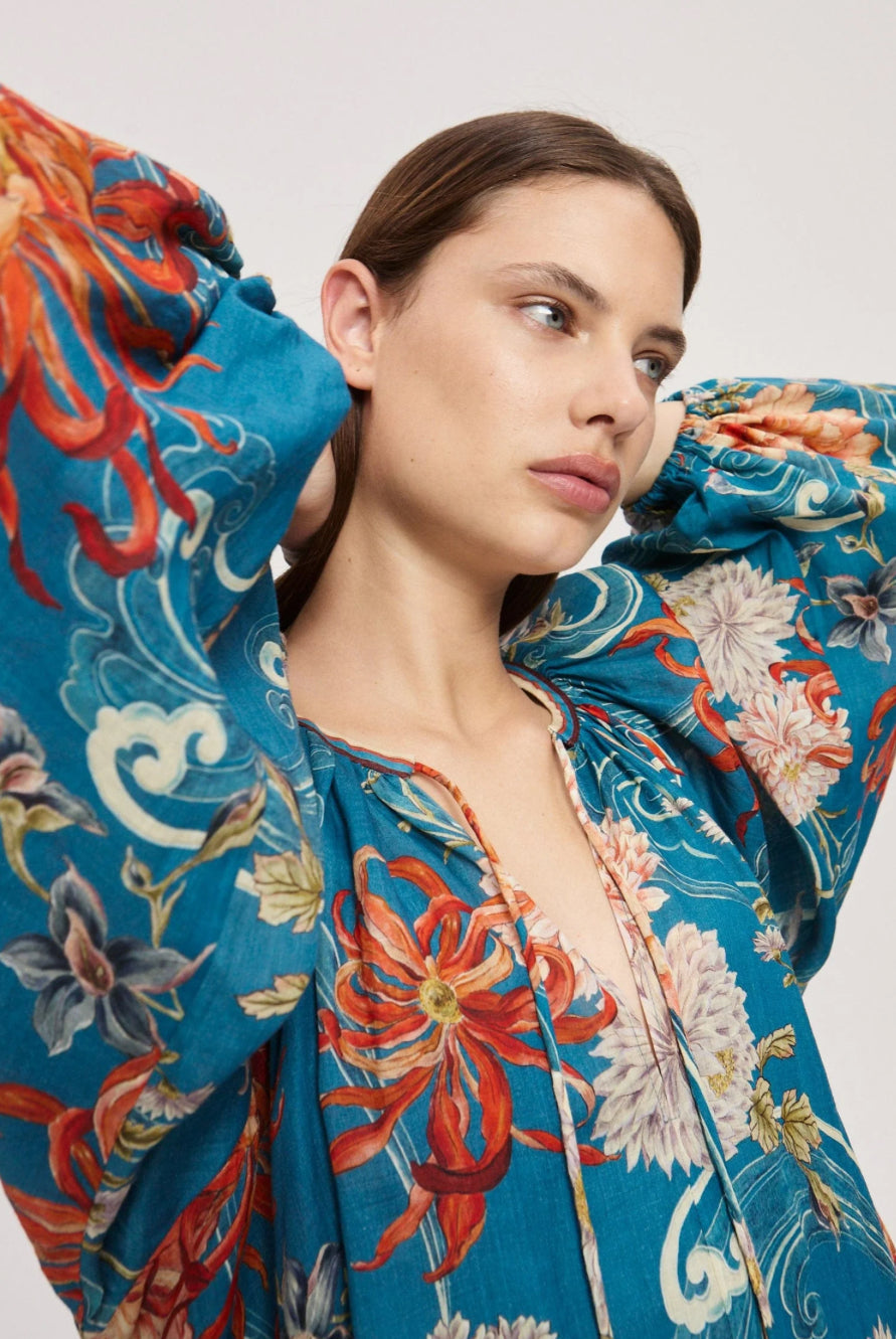 Woman wearing a colorful floral dress with a neutral background
