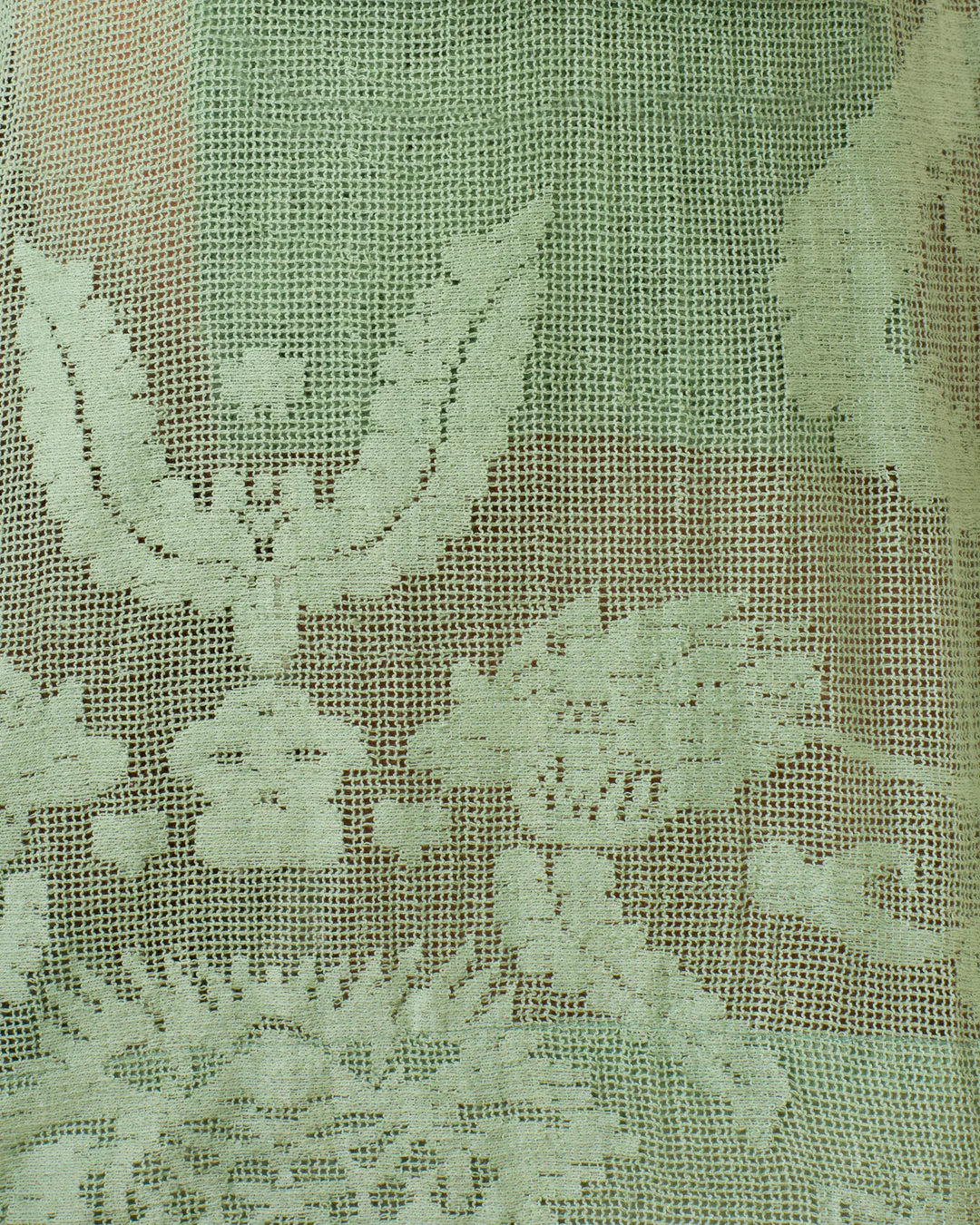 Close-up of green lace fabric with intricate patterns