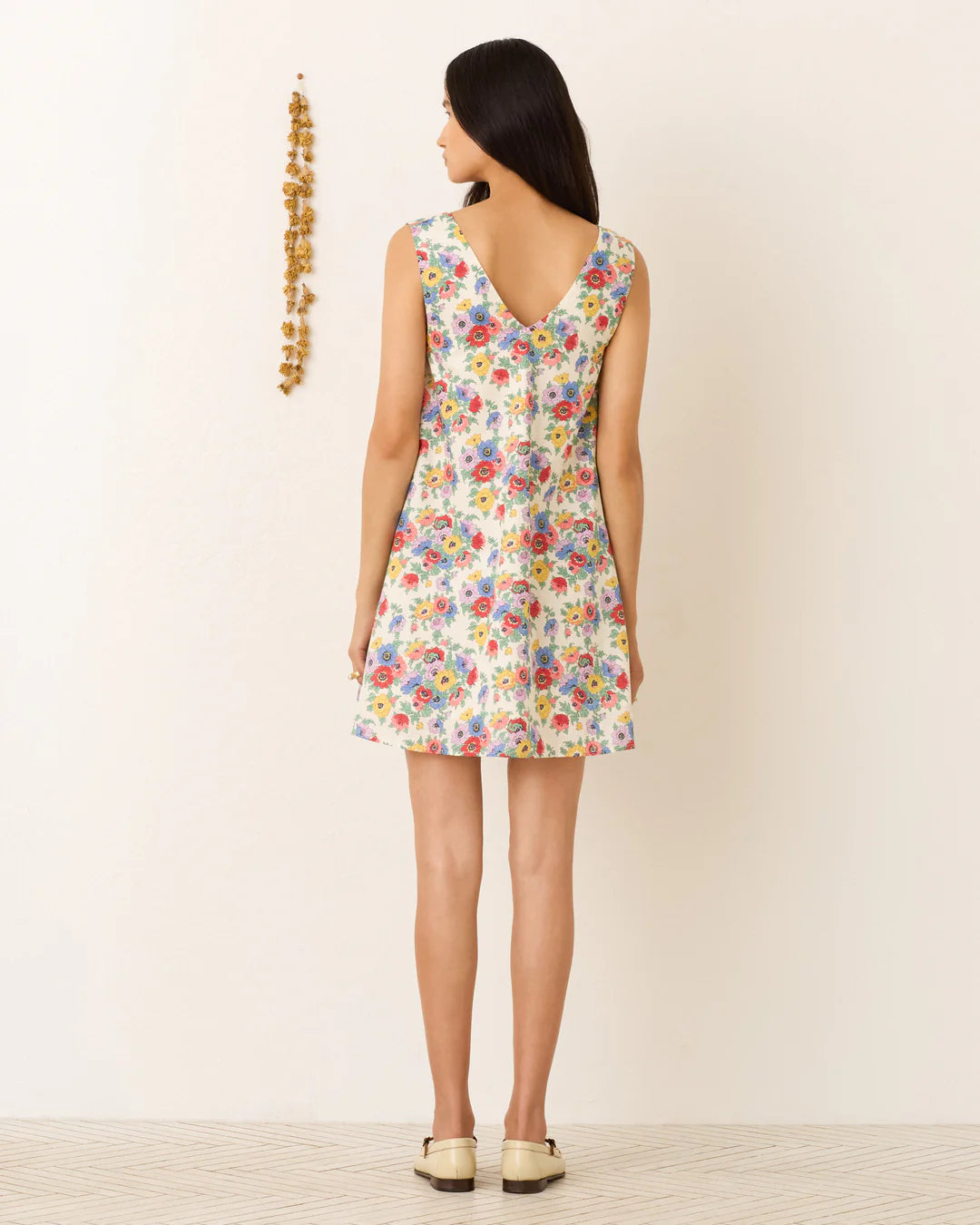 Woman wearing a floral dress with a plain background