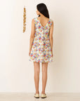 Woman wearing a floral dress with a plain background