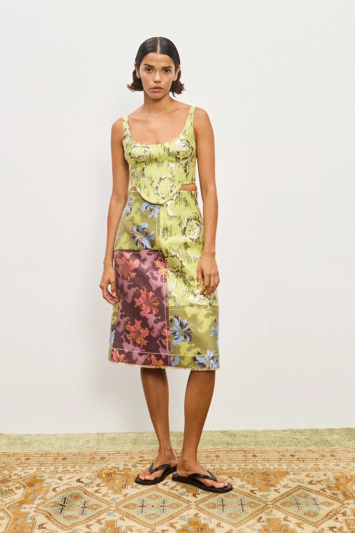 Woman wearing a floral dress with a plain background. Alamais Adriana Skirt