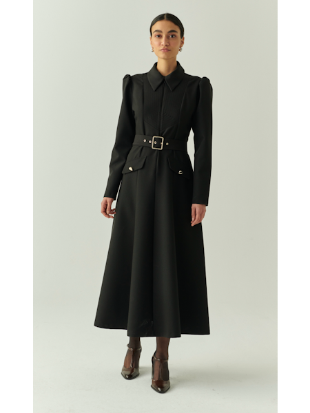 Woman wearing a black dress with a belt on a white background