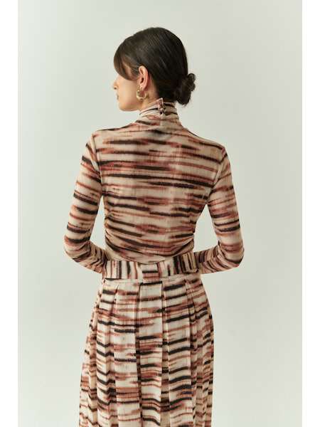 Woman wearing a patterned dress with a plain background
